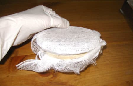 Container with cheesecloth attached
