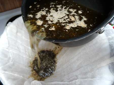 Pour weed butter mixture through the cheese cloth to strain out all the plant matter