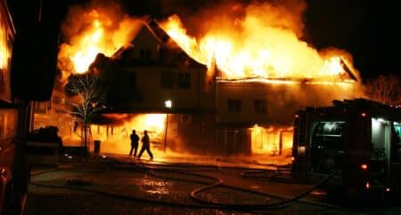 Firefighters trying to extinguish a two businesses engulfed in flames