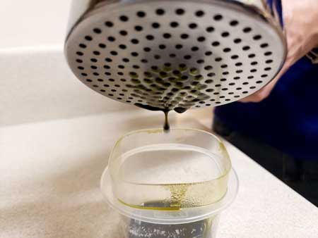 A potato ricer being used to squeeze out cannabis oil